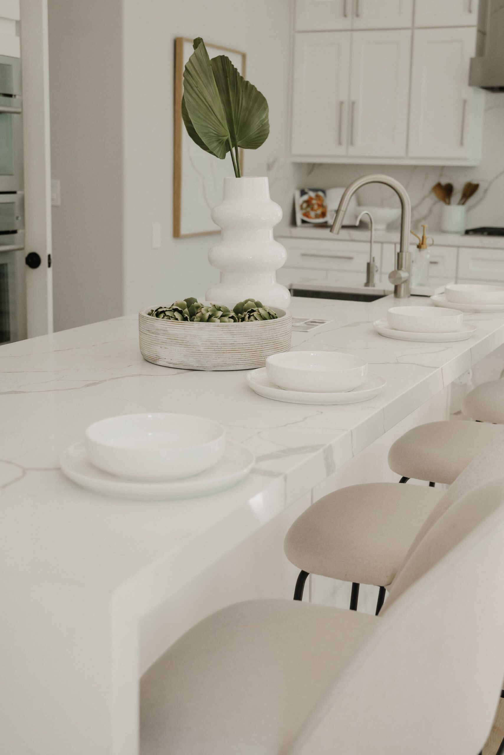 Elegant minimalist kitchen with a sleek white countertop and stylish decor.